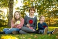 Two big sisters and their toddler brother having fun outdoors. Two young girls with a toddler boy on autumn day. Children with Royalty Free Stock Photo