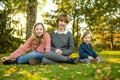 Two big sisters and their toddler brother having fun outdoors. Two young girls with a toddler boy on autumn day. Children with Royalty Free Stock Photo