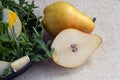Two big sweet pears near the black plate. Easy tasty summer salad with pear, arugula, brie cheese, pine nuts, honey sauce. The