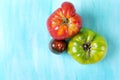 Two big tomatoes of green and red colors and a small plum tomato Royalty Free Stock Photo