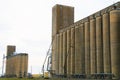 Two big working agricultural farm community feed grain and corn silo buildings in a small town in rural heartland america perfect Royalty Free Stock Photo