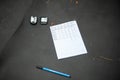 Two bike speedometers of cyclists lying on the needles grey sleeping mat pad in coniferous forest with pen and notebook. Close up