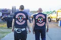 Two bikers standing on a street. Writings in Russian on back side of jackets meaning titles of their gangs - Scumbags Ukraine and