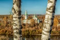 Two birch trunks against a blurred background of the Church of the Transfiguration of the Lord in Kungur.