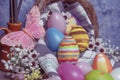 Butterfly with colored Easter eggs in a straw corp close with flowers selective focus Royalty Free Stock Photo