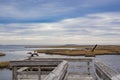 Two Birds Take Flight at the End of a Pier with Cloud and Sky Above Royalty Free Stock Photo