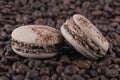 Two biscuit coffee meringues cookies lie on the background of coffee beans