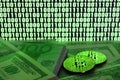 Two bitcoins lies on a pile of dollar bills on the background of a monitor depicting a binary code of bright green zeros and one u Royalty Free Stock Photo