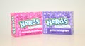 Two bite size servings of strawberry and grape nerds