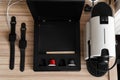 Two black apple watch on charge, coffee machine with capsules on wooden table