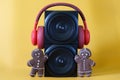 Two black audio speakers, red headphones and funny gingerbread men on a yellow background. ÃÂ¡oncept of a holiday party, disco, pop
