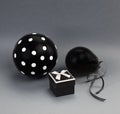 Two black balloons one of them with white polka dots on it and a black box with an open lid.