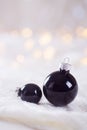 Two black Christmas balls on white lace on light and warm bokeh Royalty Free Stock Photo