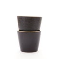 Two black coarse porcelain tea cups on white background