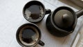 Two black coffee cups and clay ibrik on the wooden salver