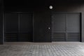 Two black corrugated doors - service entrance of building