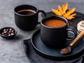Two black cups of coffee on a black plate with a spoon Royalty Free Stock Photo