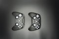 Two black game joysticks with white buttons isolated on gray background