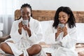 Two black girlfriends enjoying morning coffee at home