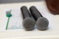 Two black karaoke microphones stand on a white table Royalty Free Stock Photo