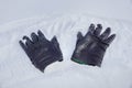 Two black leather gloves on the snow. it`s time for winter clothes Royalty Free Stock Photo