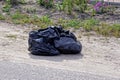 Two black plastic bags with garbage stand on the gray ground Royalty Free Stock Photo