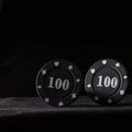 Two black poker chips on a dark background Royalty Free Stock Photo