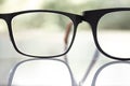 Two black shortsighted or nearsighted eyeglasses on white acrylic table, Bokeh green garden background, Close up & Macro shot