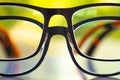 Two black shortsighted or nearsighted eyeglasses on white acrylic table, Bokeh green garden background, Reflection, Optical