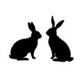 Two black silhouettes of rabbits sitting and facing each other closely high quality Royalty Free Stock Photo