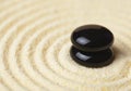 Two black stones put in a pile on sand Royalty Free Stock Photo