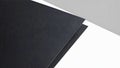 Two black textured sheets positioned at an angle against a white and gray background Royalty Free Stock Photo