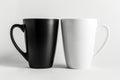 Two black and white coffee mugs sitting side by side. Perfect for coffee lovers or coffee-themed designs Royalty Free Stock Photo