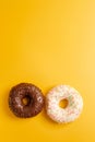 Two black and white donuts on yellow background top view Royalty Free Stock Photo