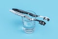 Two black and white toothbrush on a glass with mouthwash on blue background with copy space Royalty Free Stock Photo