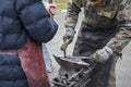 Two blacksmith are engaged in the ancient ?raditional craft of blacksmithing, shape and forge metal pieces Royalty Free Stock Photo