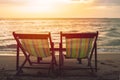 Two blank beach bed chair set on the beach with sun twilight sky background Royalty Free Stock Photo