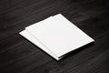 Two blank corporate identity brochure on black stylish wood background, mock up. Royalty Free Stock Photo