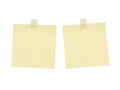 Two blank light yellow sticky notes attached with white tape on a black background Royalty Free Stock Photo