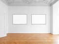Two blank picture frames hanging on white wall in empty room Royalty Free Stock Photo