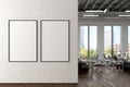 Two blank vertical posters mock up on the white brick wall in office interior. Royalty Free Stock Photo