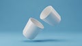 Two Blank White Ceramic Cups Floating on Blue Background Mockup Royalty Free Stock Photo