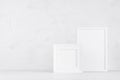 Two blank white different wooden frames in delicate soft light minimal modern white interior on wood desk, copy space. Template. Royalty Free Stock Photo