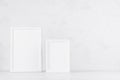 Two blank white different wooden frames in delicate soft light minimal modern white interior on wood desk, copy space. Template. Royalty Free Stock Photo