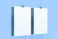 Two blank white posters with binder clip mockup on blue background Royalty Free Stock Photo