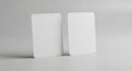 Two blank white rectangular cards standing upright against a plain light gray background Royalty Free Stock Photo