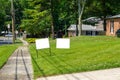 Two blank white signs on a green grassy lawn in a residential community Royalty Free Stock Photo