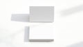 Two blank white square cards or brochures casting soft shadows on a clean white background top down view Royalty Free Stock Photo