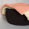 Two blankets and basket on white table