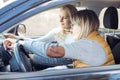 Two blond women setting gps navigator in the car. Travel and joy new trip, set connection with satellite. Driver skills Royalty Free Stock Photo